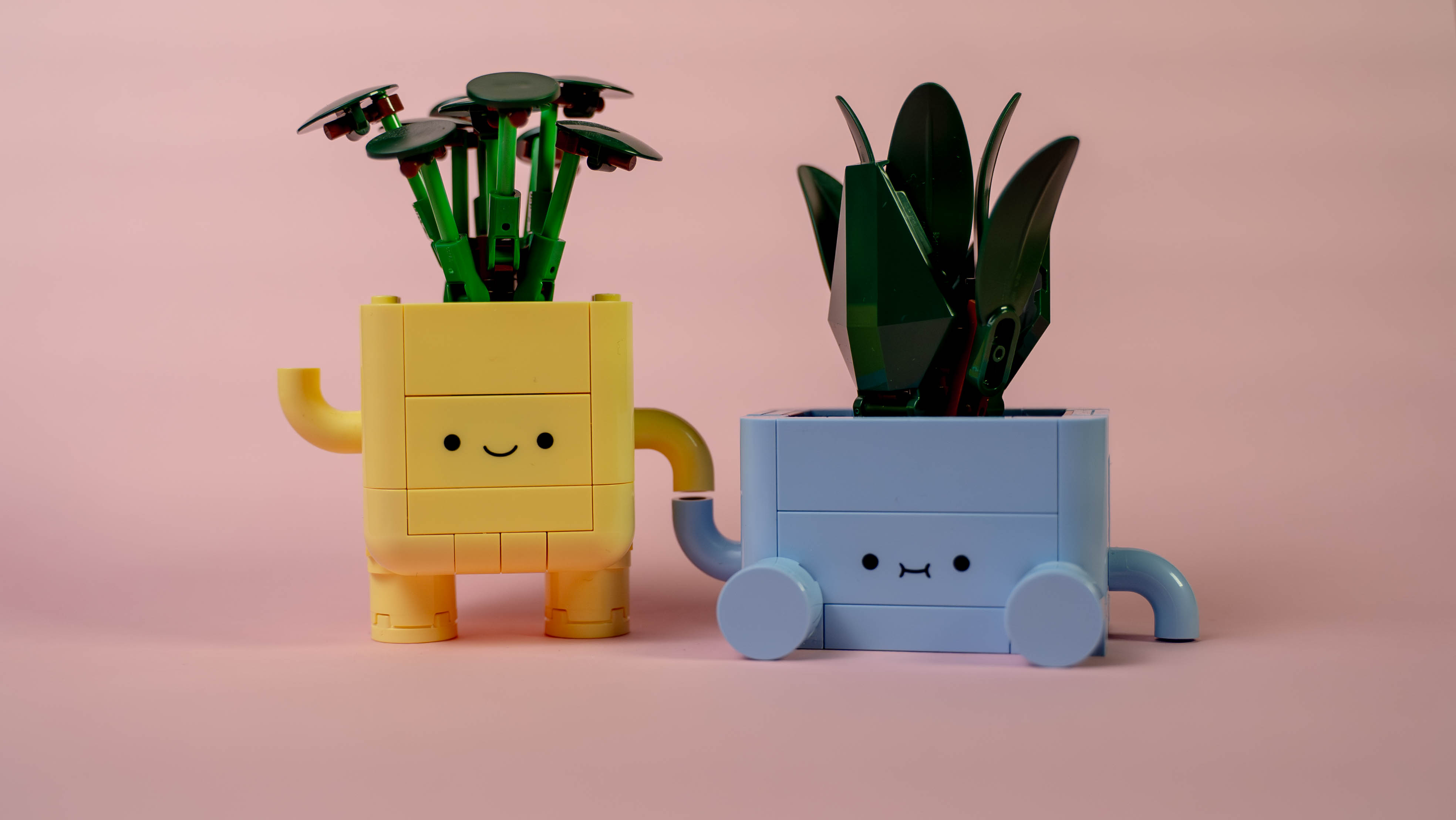 Produkt billede af to smilende lego plantepotter med arme og ben og nogle planter som hår